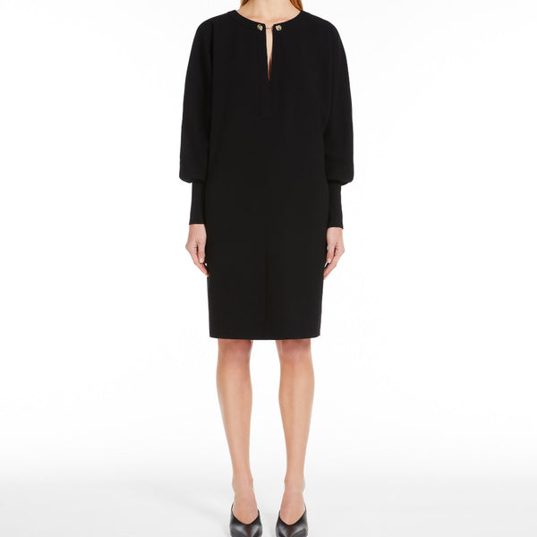 Short dress in heavy cady, featuring a tunic silhouette with long batwing sleeves and wide knit cuffs. Finished with pockets inserted in the sides and a round neckline fastened with a jewelled stud button.