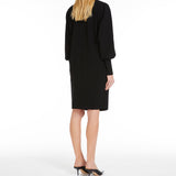 Short dress in heavy cady, featuring a tunic silhouette with long batwing sleeves and wide knit cuffs. Finished with pockets inserted in the sides and a round neckline fastened with a jewelled stud button.